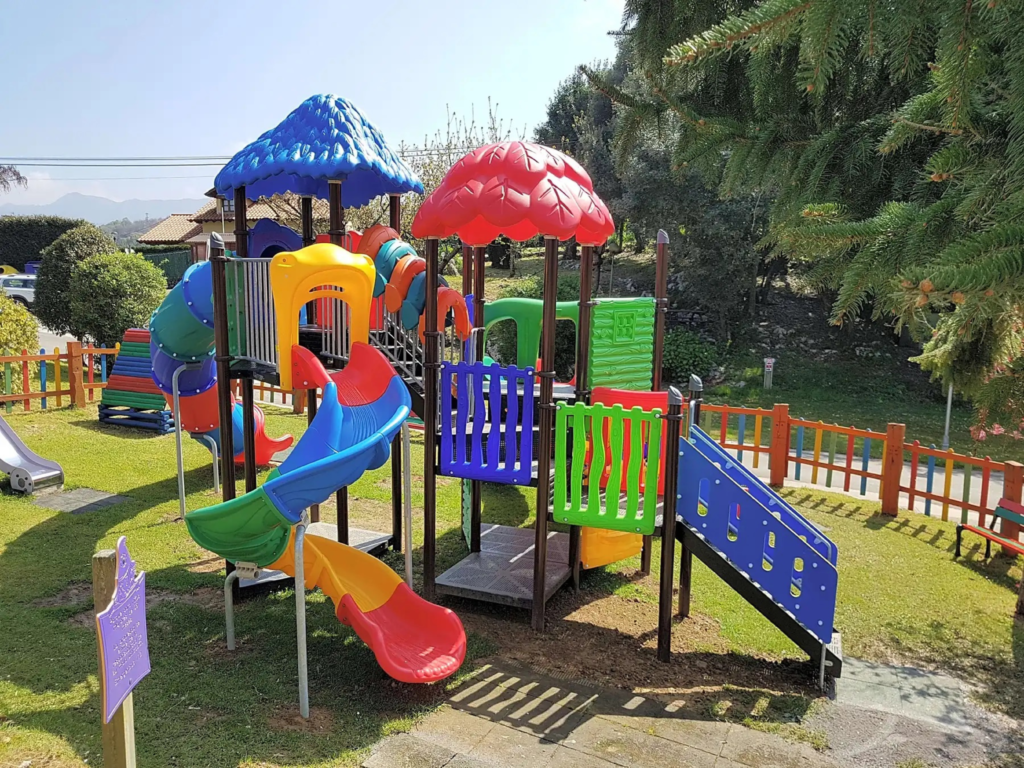 Parque infantil del Camping Ribadesella con toboganes y zona vallada