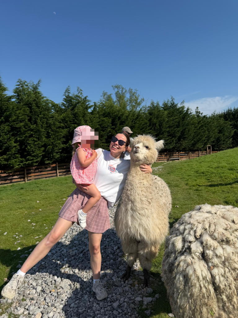 Mamá y niña junto a una alpaca en La Fuentona de Santillana