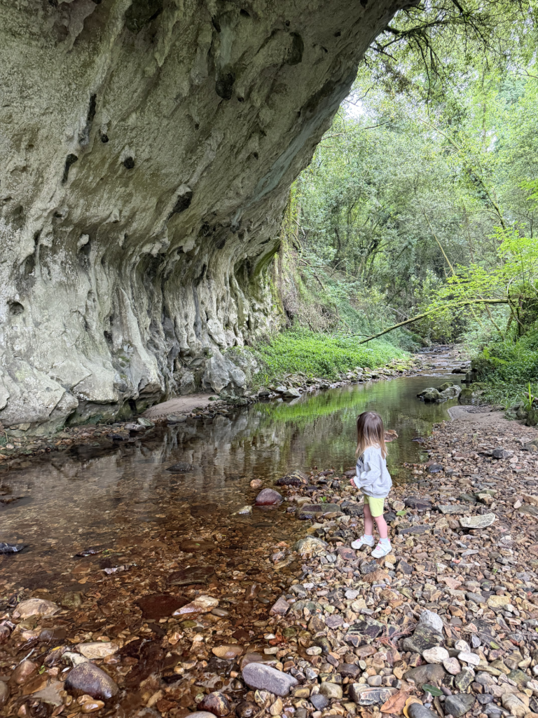 Niña junto al río bajo el Arco de Torre cerca de Ribadesella